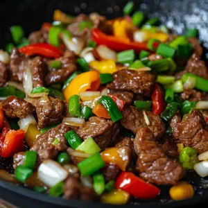 A serving of Garlic Pepper Beef on a plate, showcasing juicy beef strips in a rich garlic and pepper sauce, accompanied by a side of vegetables.